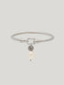 Silver ALEXA bangle bracelet with a dangling freshwater pearl on a light background
